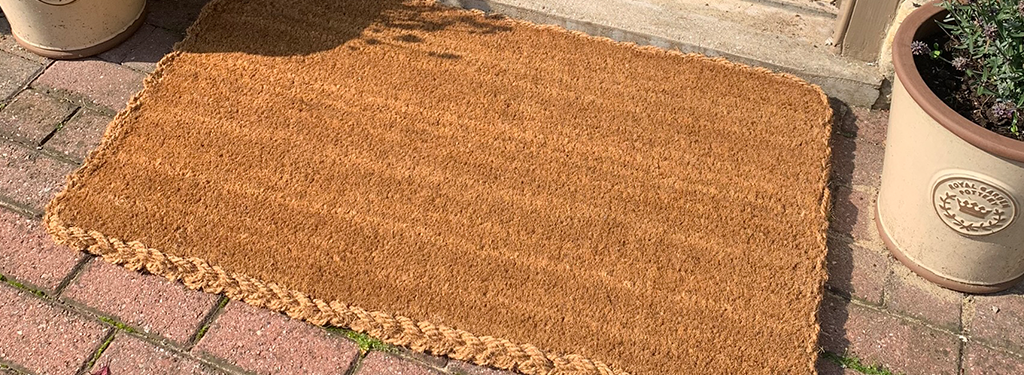 A traditional coir mat with a woven backing will allow water to run away so is the best option when coir is used outdoors